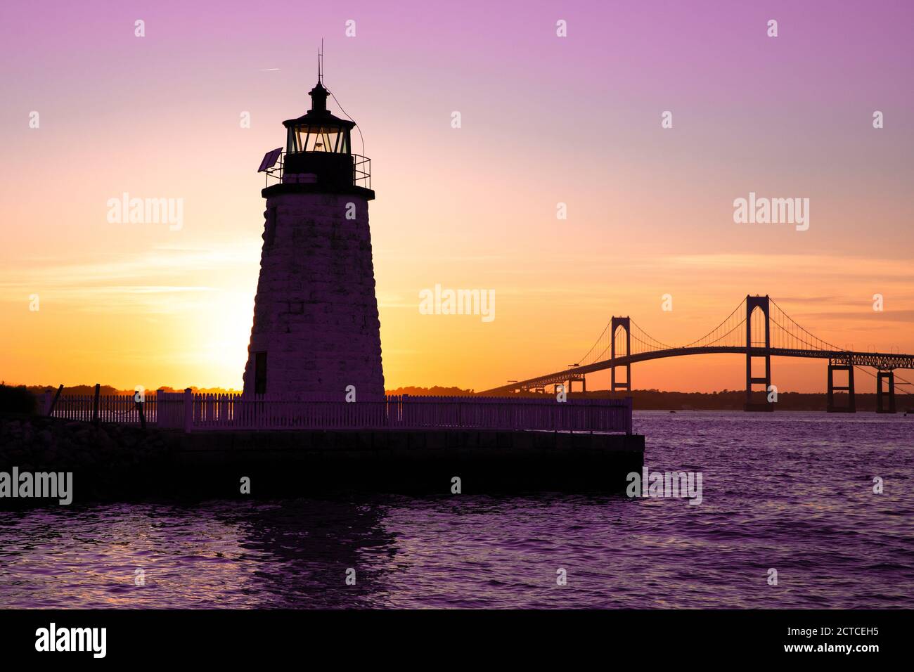 Sonnenuntergang über Newport Harbor Lighthouse mit Brücke und buntem Himmel Stockfoto