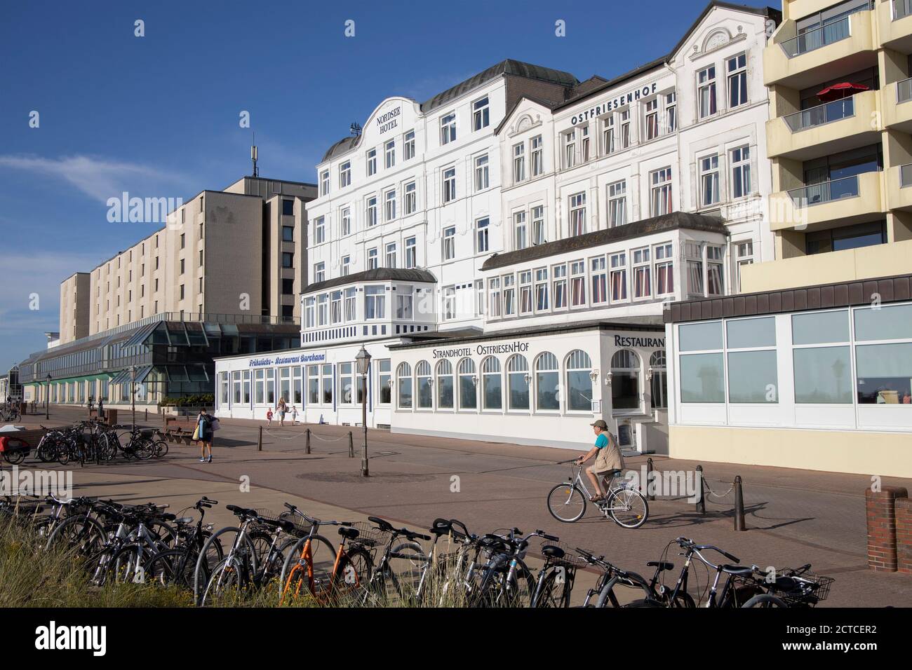Einsamer Radfahrer auf der Promenade während der Corona-Pandemie auf Borkum-Insel, Niedersachsen, Deutschland, Europa. Stockfoto