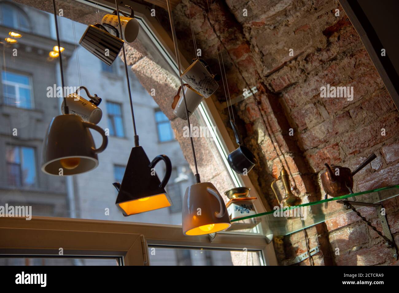Die Lichter sind aus verschiedenen Tassen, die am Fenster hängen. Stockfoto