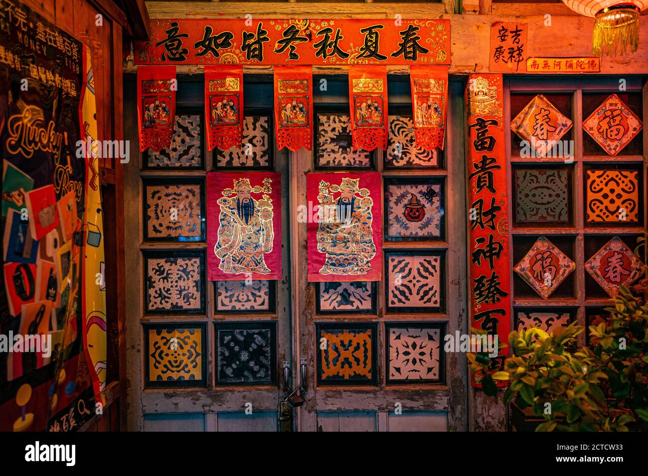 Eine Vorderseite eines traditionellen taiwanesischen Hauses mit geschlossenen Türen. Es gibt einige alte chinesische Neujahrsdekoration, Tür-gott und Couplet. Stockfoto