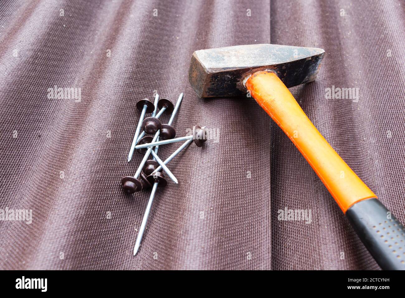 Nahaufnahme auf Asphalt Dachschindeln Hintergrund mit Hammer und Nägel. Stockfoto