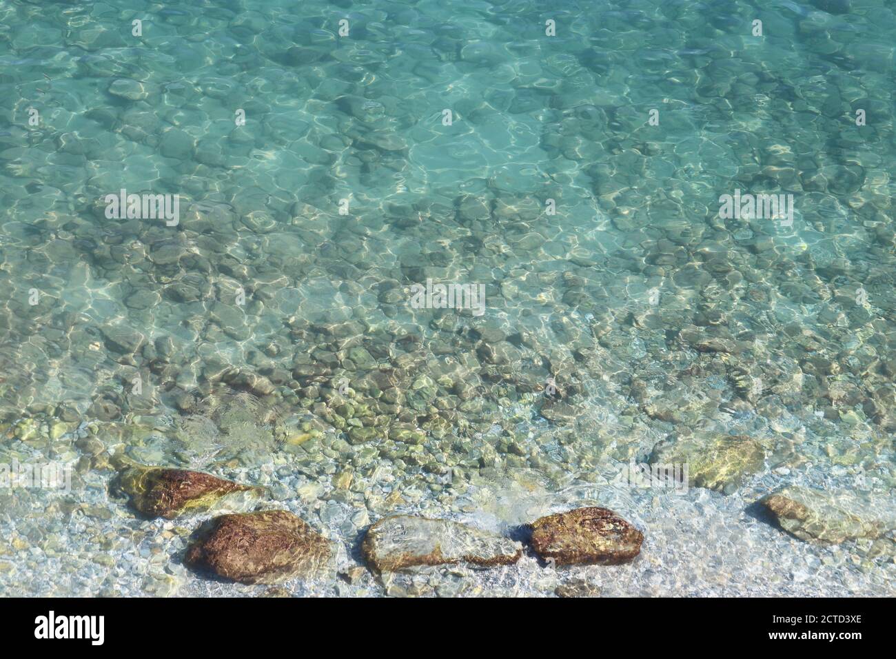 Azure Wasser Textur, transparente Meeresoberfläche mit einem felsigen Boden. Luftaufnahme, natürlicher blauer Hintergrund Stockfoto