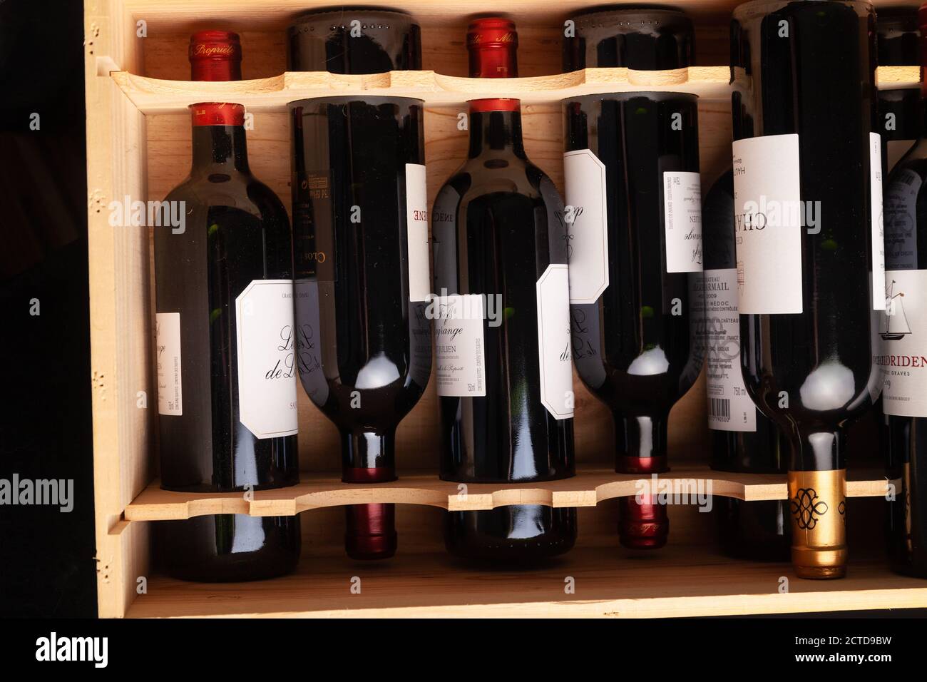 Flaschen Rotwein liegen flach in einer Holzkiste. Stockfoto