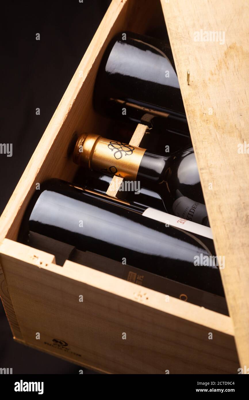 Flaschen Rotwein liegen flach in einer Holzkiste. Stockfoto