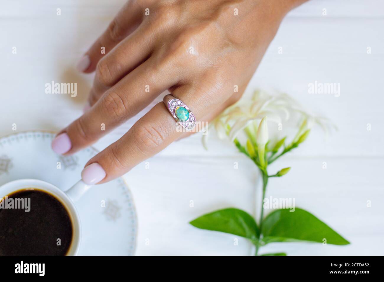 Keramik Tasse Kaffee mit Blumen in Frauen gut gepflegte Hände mit Maniküre. Stockfoto
