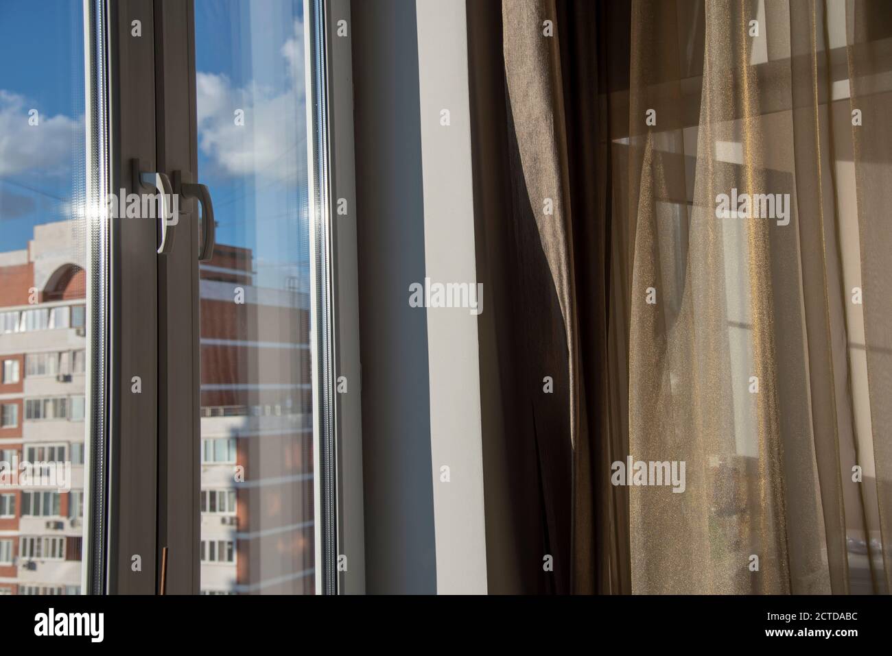 Fragment eines Zimmerfensters, durch das ein Wohngebäude sichtbar ist. Stockfoto