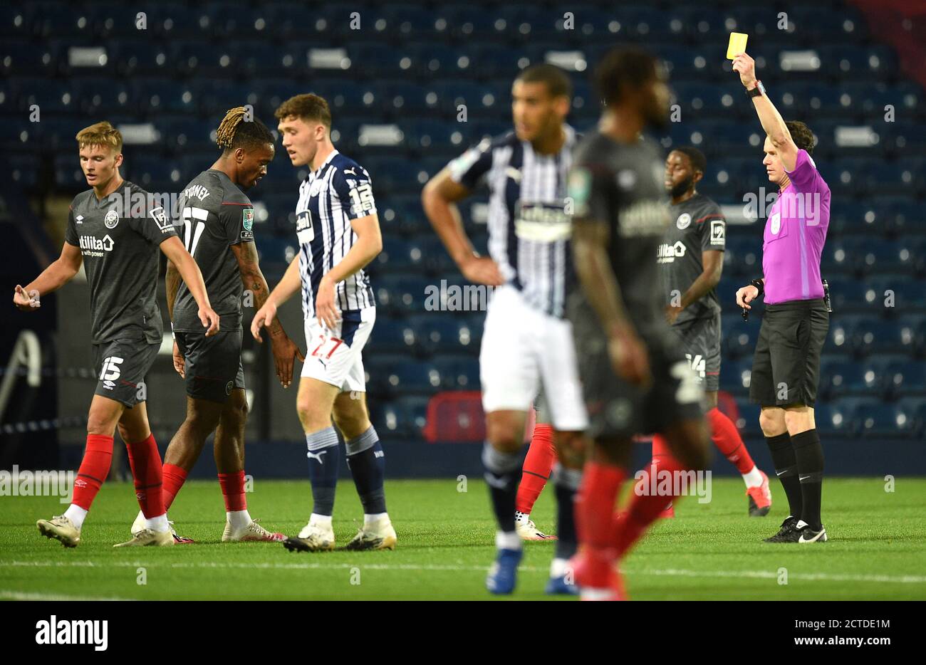 Schiedsrichter Darren England (rechts) zeigt eine gelbe Karte für Dara O'Shea von West Bromwich Albion während des Carabao Cup-Spiels in der dritten Runde der Hawthorns, West Bromwich. Stockfoto