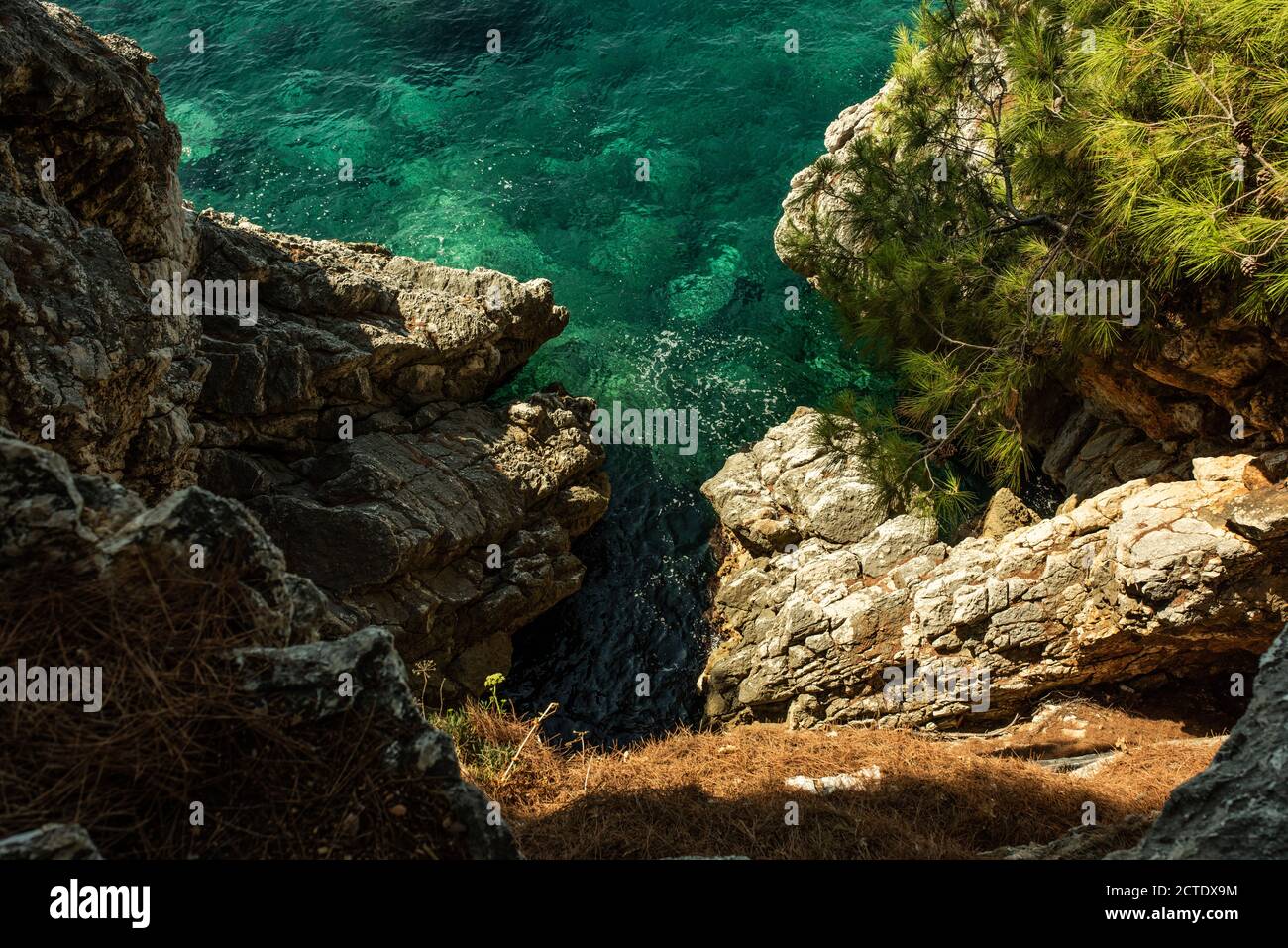 Felsige Klippen mit reinem sauberen grünen und blauen Wasser der Adria in der Nähe von Sveti Stefan Insel. Unheimliche Aussicht von oben. Stockfoto