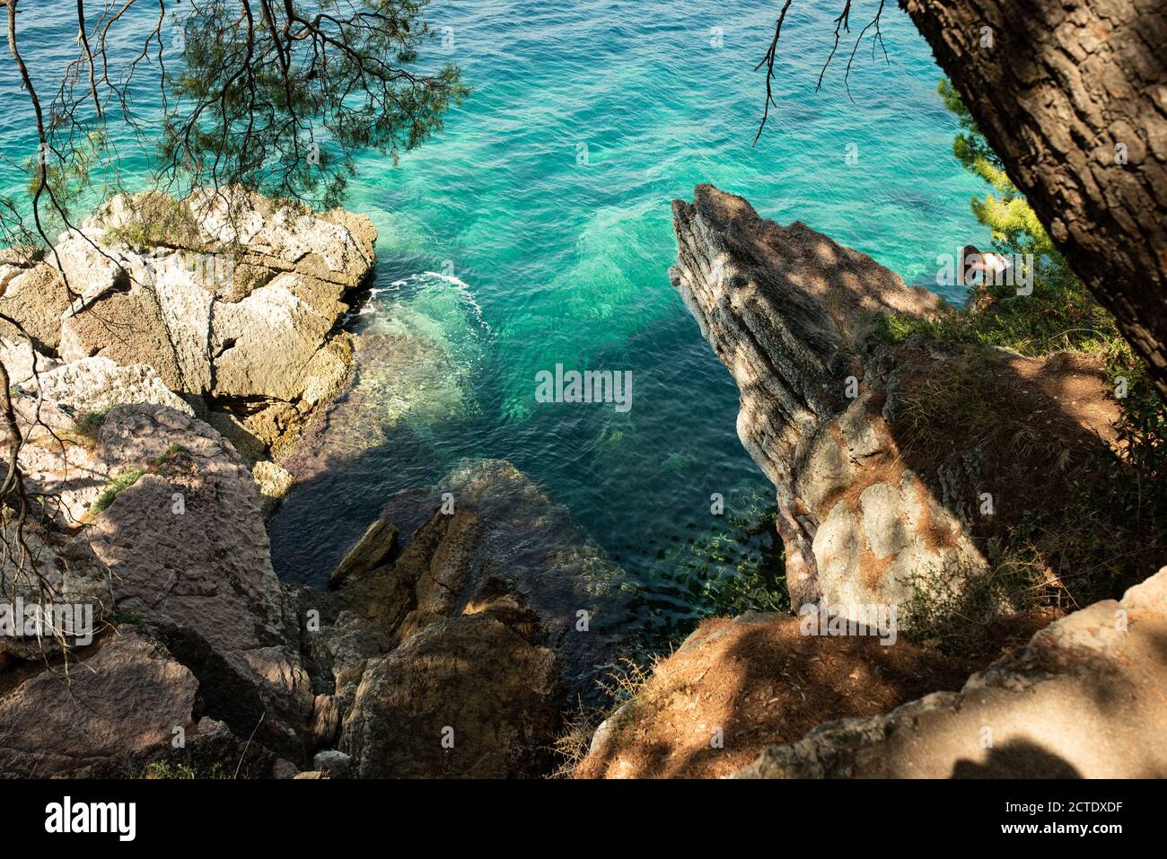 Felsige Klippe zum Springen im Wasser oder machen beängstigend Selfies mit extremer Höhe und reinem sauberen Wasser der Adria. Blick vom Fußweg in der Nähe des Luxus-Resorts Sveti Stefan. Stockfoto