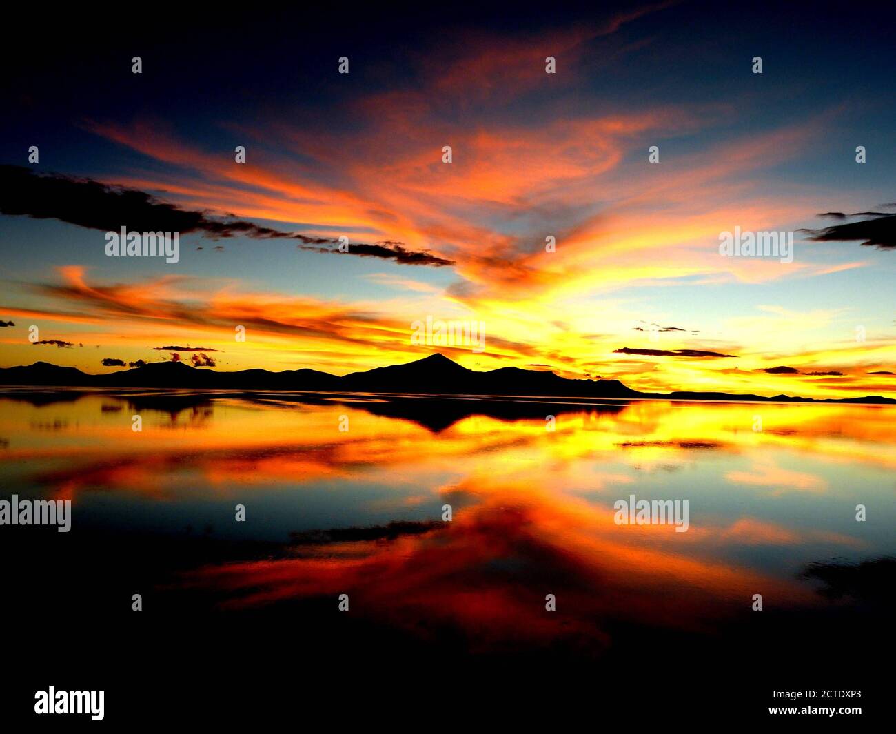 Wunderschöner Sonnenuntergang. Orangefarbener Sonnenuntergang. Spektakuläre Himmel Wolken Reflexion im Salzsee Wasser. Farbiger Himmel.surreale Wüstenlandschaft.Salar de Uyuni, Bolivien Stockfoto