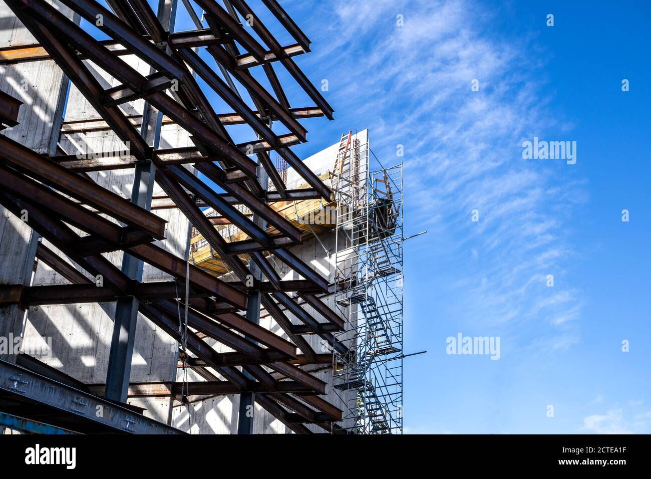 Teilbau eines mehrstufigen Industriegebäudes. Stahlrahmen/Metallbalken sichtbar mit Gehwegen und Leitern. Eckansicht. Stockfoto