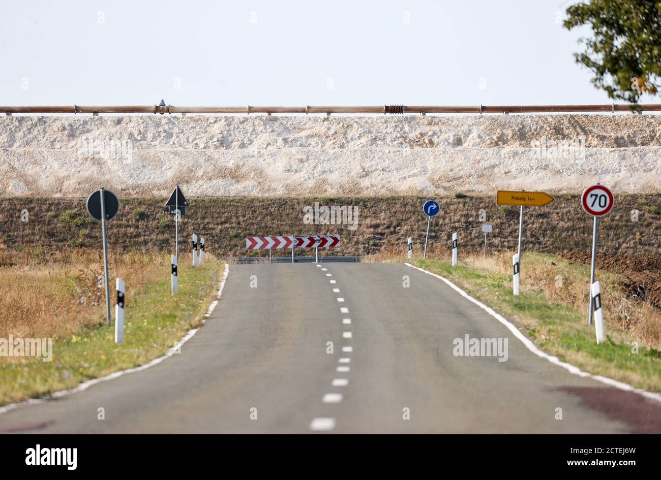 17. September 2020, Sachsen-Anhalt, Latdorf: Die Landstraße L73 scheint an der Wand eines Kalkteiches zu enden. Während eines Erdrutsches im Jahr 2012 wurde die Straße überspült, dann geschlossen, eine Umgehungsstraße gebaut und das Brachland genutzt, um einen weiteren Kalkteich zu schaffen. Die mehrere Hektar großen Siedelteiche werden zur Aufbereitung von Produktionsabwässern aus der Sodaproduktion genutzt. Dabei setzen sich Kalk und Rückstände ab, das gereinigte Wasser fließt in die Saale. Die Sedimente bewirken, dass die Hügel stetig wachsen. Die Solvay GmbH produziert Soda, Natriumhydrogencarbonat, hochreines Wasserstoffperoxid und High Stockfoto