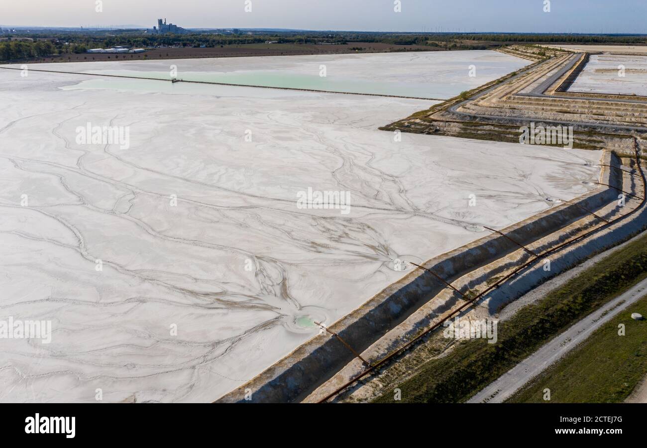 17. September 2020, Sachsen-Anhalt, Latdorf: Das Spülwasser erzeugt auf einem Kalkteich unterschiedliche Muster. Die mehrere Hektar großen Siedelteiche werden zur Behandlung von Produktionsabwässern aus der Sodaproduktion verwendet. Dabei setzen sich Kalk und Rückstände ab und das gereinigte Wasser fließt in die Saale. Die Sedimente bewirken, dass die Hügel stetig wachsen. Die Solvay GmbH produziert seit 130 Jahren Soda, Natriumhydrogencarbonat, hochreines Wasserstoffperoxid und hochreine Phosphorsäure für die Herstellung von Computerchips. (Luftaufnahme mit Drohne) Foto: Jan Woitas/dpa-Zentralbild/ZB Stockfoto