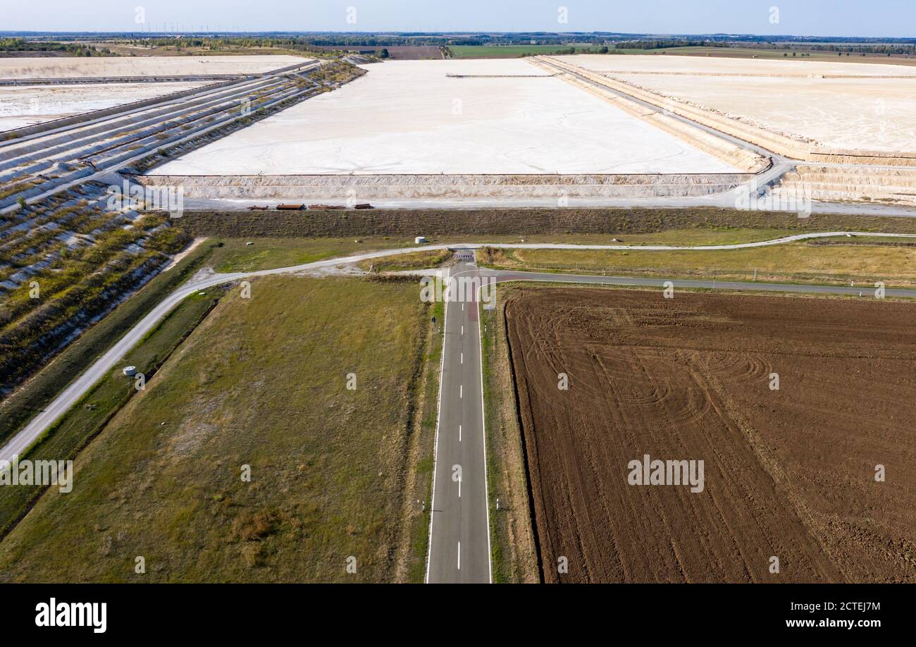 17. September 2020, Sachsen-Anhalt, Latdorf: Die Landstraße L73 scheint an der Wand eines Kalkteiches zu enden. Während eines Erdrutsches im Jahr 2012 wurde die Straße überspült, dann geschlossen, eine Umgehungsstraße gebaut und das Brachland genutzt, um einen weiteren Kalkteich zu schaffen. Die mehrere Hektar großen Siedelteiche werden zur Aufbereitung von Produktionsabwässern aus der Sodaproduktion genutzt. Dabei setzen sich Kalk und Rückstände ab, das gereinigte Wasser fließt in die Saale. Die Sedimente bewirken, dass die Hügel stetig wachsen. Die Solvay GmbH produziert Soda, Natriumhydrogencarbonat, hochreines Wasserstoffperoxid und High Stockfoto