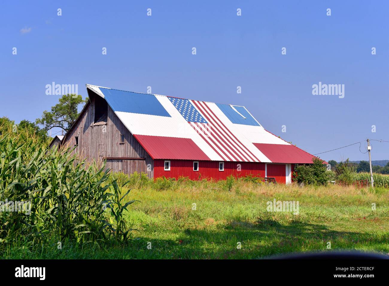 Sabula, Iowa, USA. Eine alte Veteranenscheune mit einem patriotischen rot, weiß und blau Dach komplett mit einer amerikanischen Flagge. Stockfoto