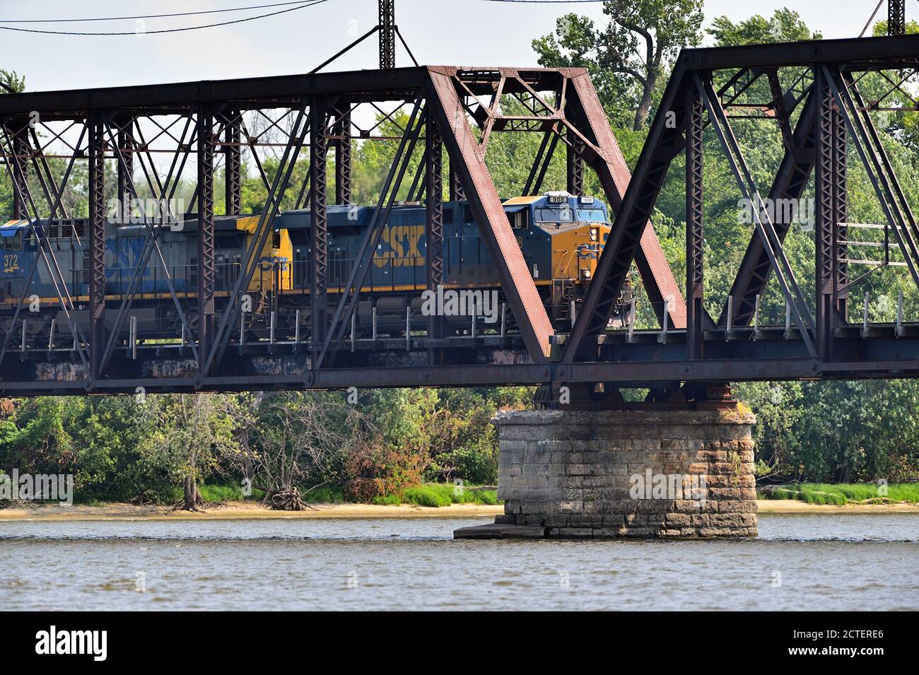 Savanna Township, Illinois, USA. Ein Güterzug, der von zwei CSX Transportlokomotiven auf einer alten Hängebrücke geführt wurde, überquerte den Mississippi. Stockfoto