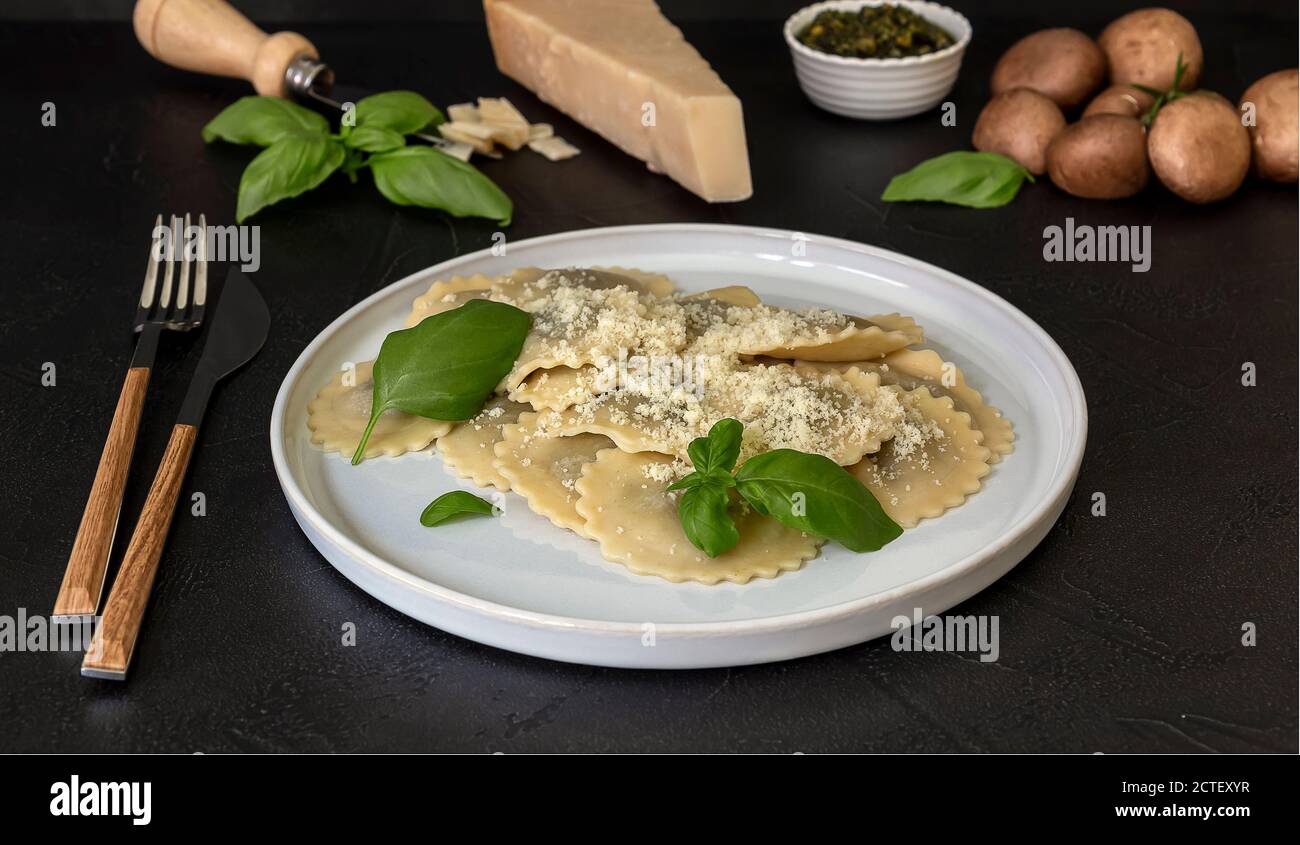 Gekochte Ravioli oder Tortelli mit Käse, Basilikum und Pilzen. Stockfoto