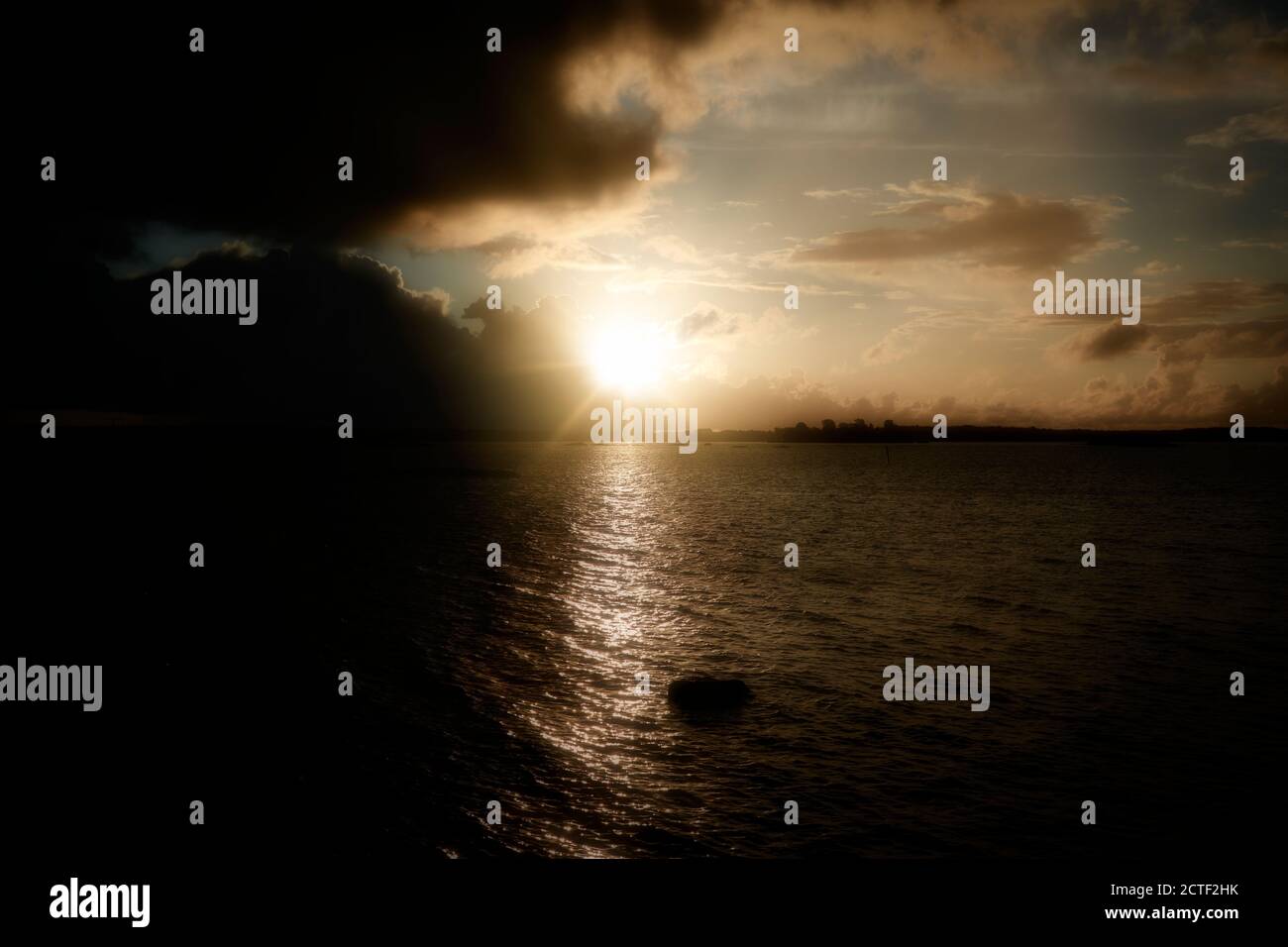 Mystischer Morgen, Sonnenaufgang über dem Meer mit dunklen Wolken. Stockfoto