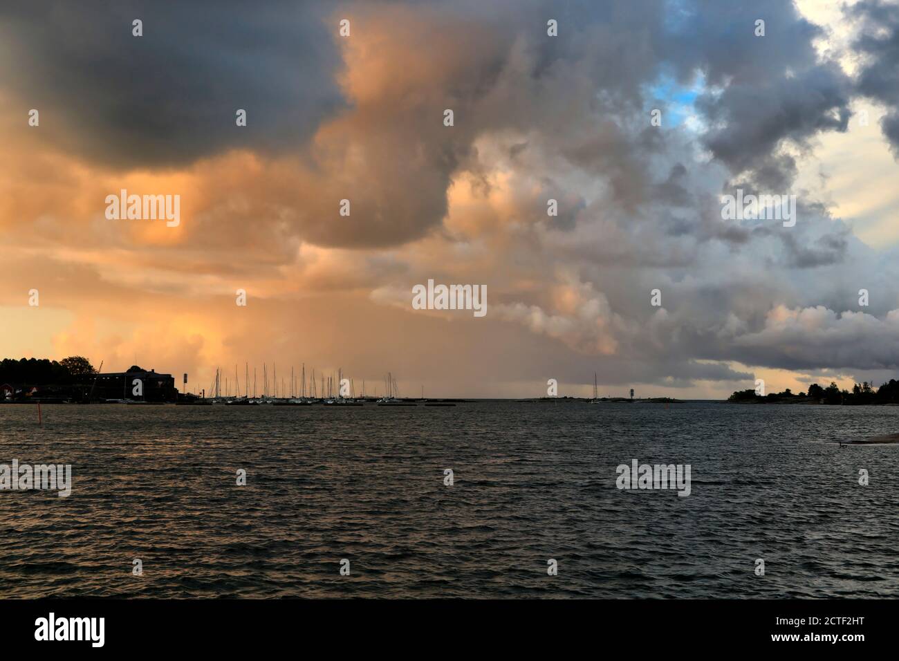 Dunkle Wolken, die in Helsinki, Finnland, einen Sturm über dem Meer vorhersagen, wenn die Sonne aufgeht. Stockfoto