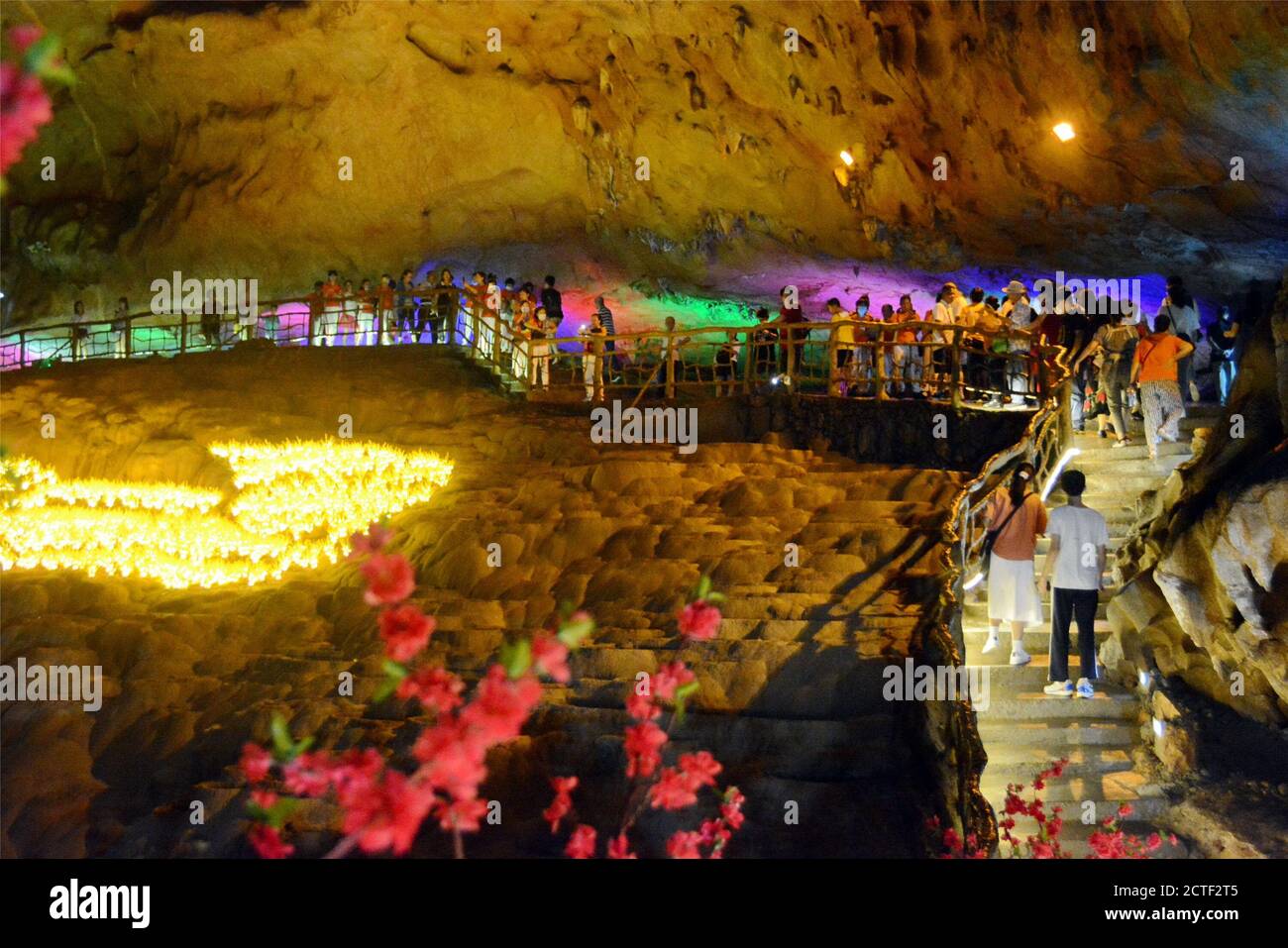 Indem sie Spiele spielen und sich mit roten Blumen kleiden, versuchen über 1500 Paare, die von der Aktivität angezogen wurden, traditionelle chinesische Hochzeitszeremonie in einem Ka Stockfoto