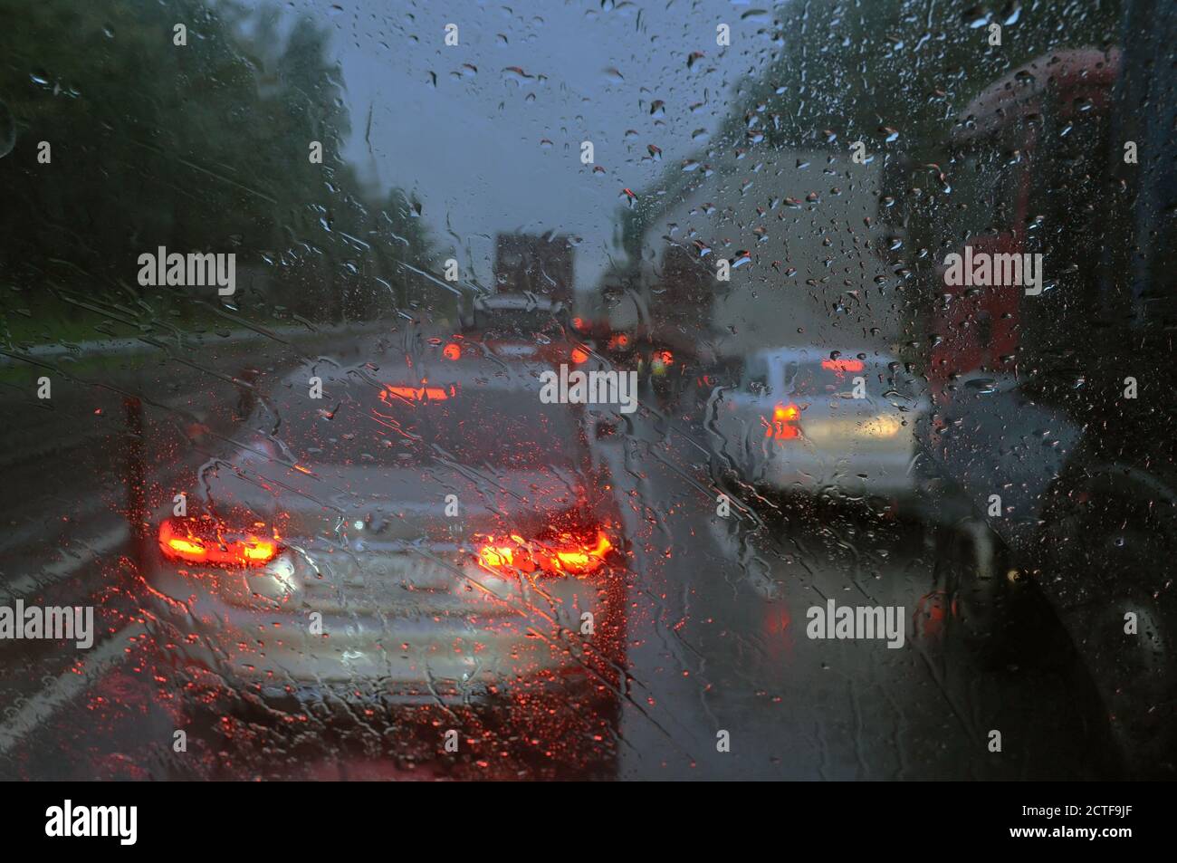 Verschwommener Hintergrund mit Regentropfen auf Glas und Autos auf der Straße. Unscharf, Unschärfe Stockfoto