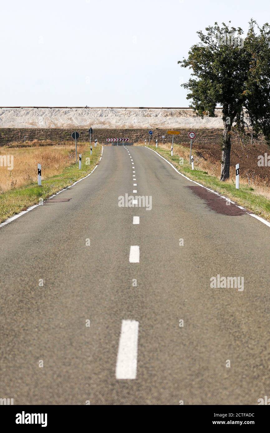 17. September 2020, Sachsen-Anhalt, Latdorf: Die Landstraße L73 scheint an der Wand eines Kalkteiches zu enden. Während eines Erdrutsches im Jahr 2012 wurde die Straße überspült, dann geschlossen, eine Umgehungsstraße gebaut und das Brachland genutzt, um einen weiteren Kalkteich zu schaffen. Die mehrere Hektar großen Siedelteiche werden zur Aufbereitung von Produktionsabwässern aus der Sodaproduktion genutzt. Dabei setzen sich Kalk und Rückstände ab, das gereinigte Wasser fließt in die Saale. Die Sedimente bewirken, dass die Hügel stetig wachsen. Die Solvay GmbH produziert Soda, Natriumhydrogencarbonat, hochreines Wasserstoffperoxid und Stockfoto