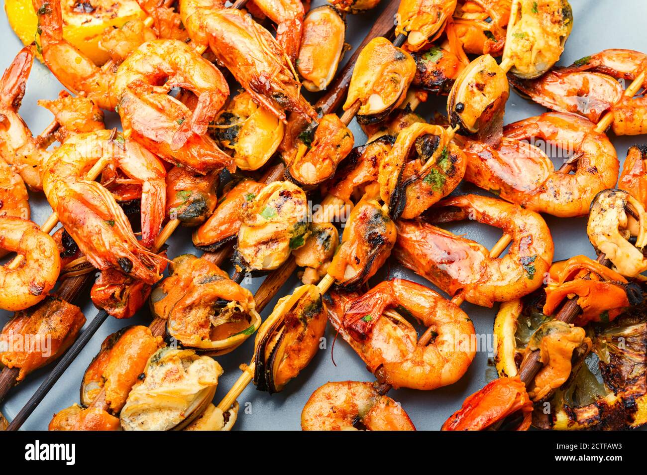 Gegrillte Garnelen und Muscheln auf Holzstäbchen Stockfoto