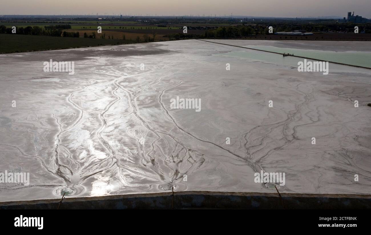 17. September 2020, Sachsen-Anhalt, Latdorf: Das Spülwasser erzeugt auf einem Kalkteich unterschiedliche Muster. Die mehrere Hektar großen Siedelteiche werden zur Behandlung von Produktionsabwässern aus der Sodaproduktion verwendet. Dabei setzen sich Kalk und Rückstände ab und das gereinigte Wasser fließt in die Saale. Die Sedimente bewirken, dass die Hügel stetig wachsen. Die Solvay GmbH produziert seit 130 Jahren Soda, Natriumhydrogencarbonat, hochreines Wasserstoffperoxid und hochreine Phosphorsäure für die Herstellung von Computerchips. (Luftaufnahme mit Drohne) Foto: Jan Woitas/dpa-Zentralbild/ZB Stockfoto