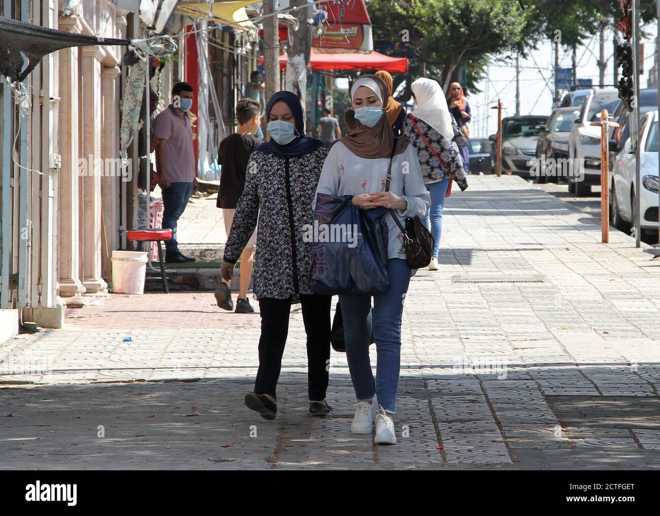 Gaza-Stadt. September 2020. Palästinenser mit Gesichtsmasken gehen am 22. September 2020 auf einer Straße in Gaza-Stadt. Palästina verzeichnete am Dienstag 557 neue Fälle, die mit dem neuartigen Coronavirus infiziert wurden, womit die Gesamtzahl der Infektionen auf 46,614 annahm. Im Gazastreifen hat die von der Hamas regierte Regierung kürzlich die Beschränkungen des Coronavirus gelockert. Kredit: Rizek Abdeljawad/Xinhua/Alamy Live Nachrichten Stockfoto