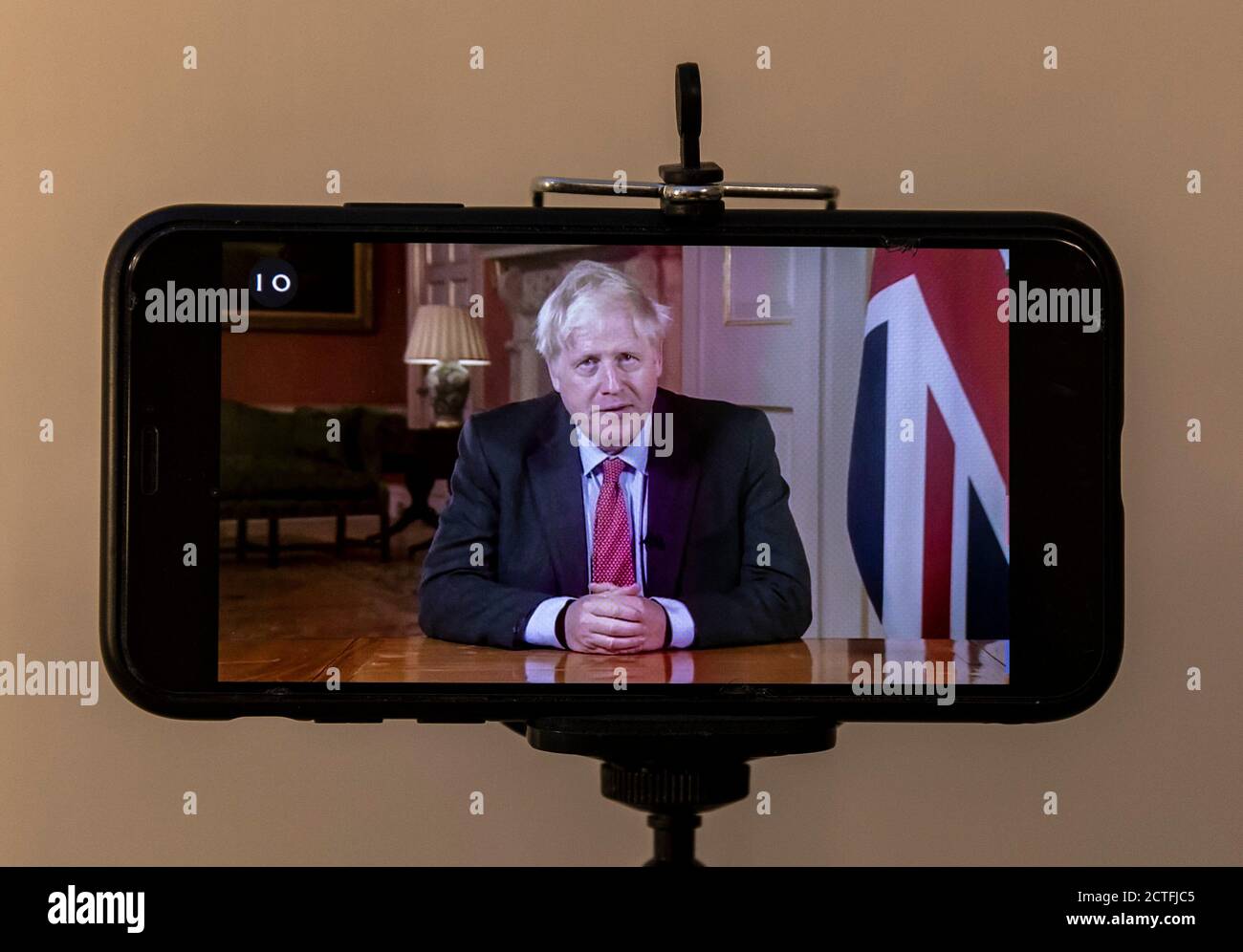 London, Großbritannien. September 2020. Das am 22. September 2020 aufgenommene Foto zeigt ein Mobiltelefon, das den britischen Premierminister Boris Johnson im Fernsehen in London, Großbritannien, an die Nation wendet. Der britische Premierminister Boris Johnson kündigte am Dienstag neue restriktive Maßnahmen an, um den starken Anstieg der Coronavirus-Fälle im Land zu bekämpfen. Johnson bestätigte, dass ab Donnerstag alle Pubs, Bars und Restaurants in England nur noch einen Tischservice betreiben müssen -- mit Ausnahme von Takeaways -- und um 10:00 Uhr BST (2100 GMT) geschlossen werden müssen. Quelle: Han Yan/Xinhua/Alamy Live News Stockfoto