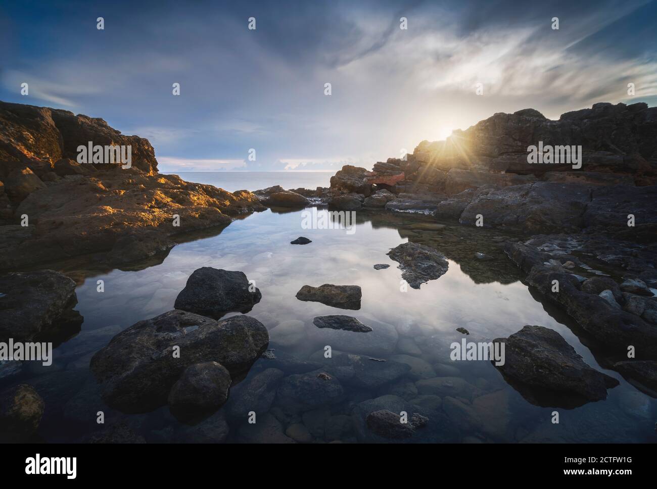 Sonnenuntergang hinter den Felsen in Castiglioncello Küste. Meer Pool in Long Exposure.Toskana, Italien. Stockfoto