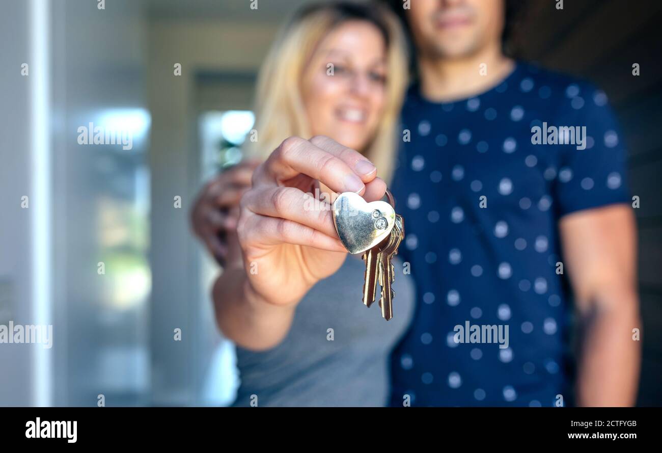 Das Paar zeigt die Schlüssel ihres Hauses Stockfoto