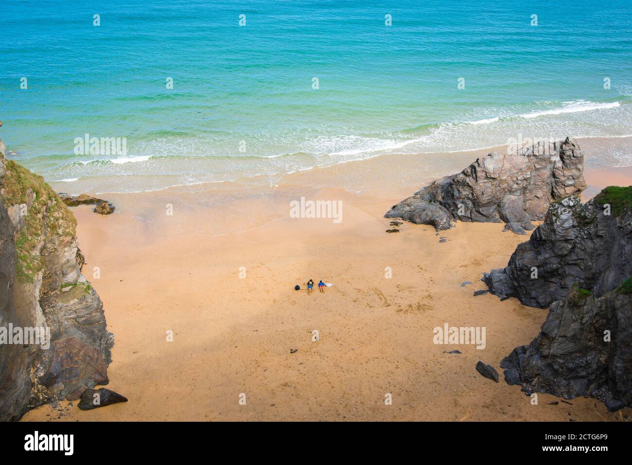 Strand für Paare allein, Blick auf ein junges Paar, das alleine an einem leeren Strand in Cornwall, England, liegt. Stockfoto