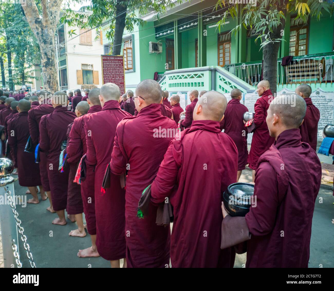 Mönche stehen zum Mittagessen im Mahagandhayon Kloster, Amarapura, Mandalay, Burma, Myanmar Stockfoto