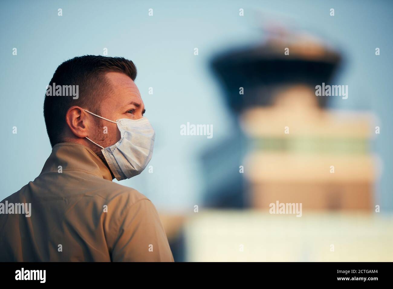Mann mit Gesichtsmaske am Flughafen. Themen Reisen in neuer Normalität, Coronavirus und persönlicher Schutz. Stockfoto
