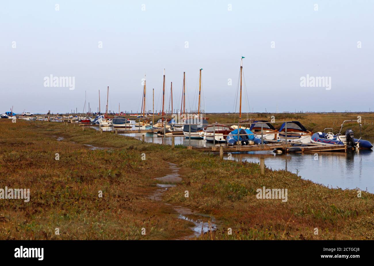 Ein Blick über Salzwiesen und Morston Creek mit festgetäuten kleinen Freizeitfahrzeugen in North Norfolk in Morston, Norfolk, England, Vereinigtes Königreich. Stockfoto