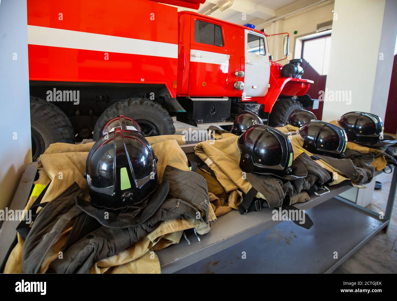 Aktobregion/Kasachstan - Mai 04 2012: Roter Feuerwehrwagen und Feuerwehrhelme und Feuerwehrkleidung. Niemand. Winkelansicht. Stockfoto