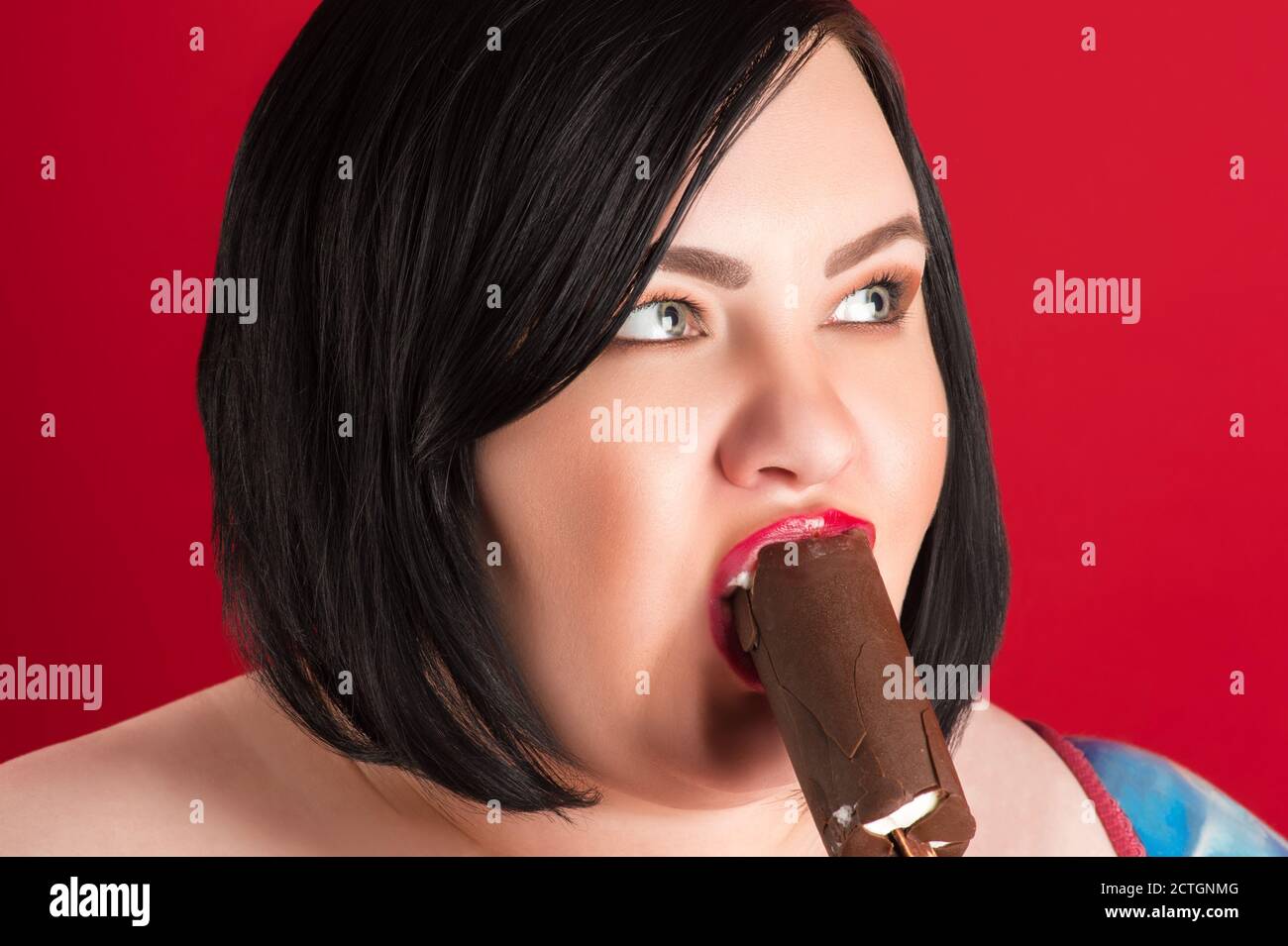 Fat Frau essen Eis aus der Nähe isoliert auf rot Hintergrund Stockfoto