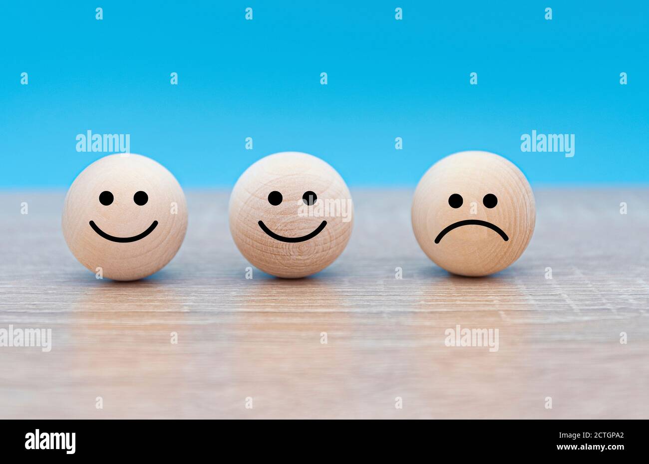 Drei hölzerne Gesichter, glückliche und traurige Gesichter, Konzeptbild über die Stimmung der Menschen Stockfoto