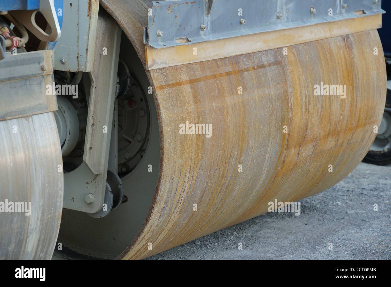 Nahaufnahme der Vordertrommel der glatten Walze des Fertiers als schweres Maschinenbaugerät an den Wochenendtagen in der Nähe der Baustelle der neuen Straße. Stockfoto