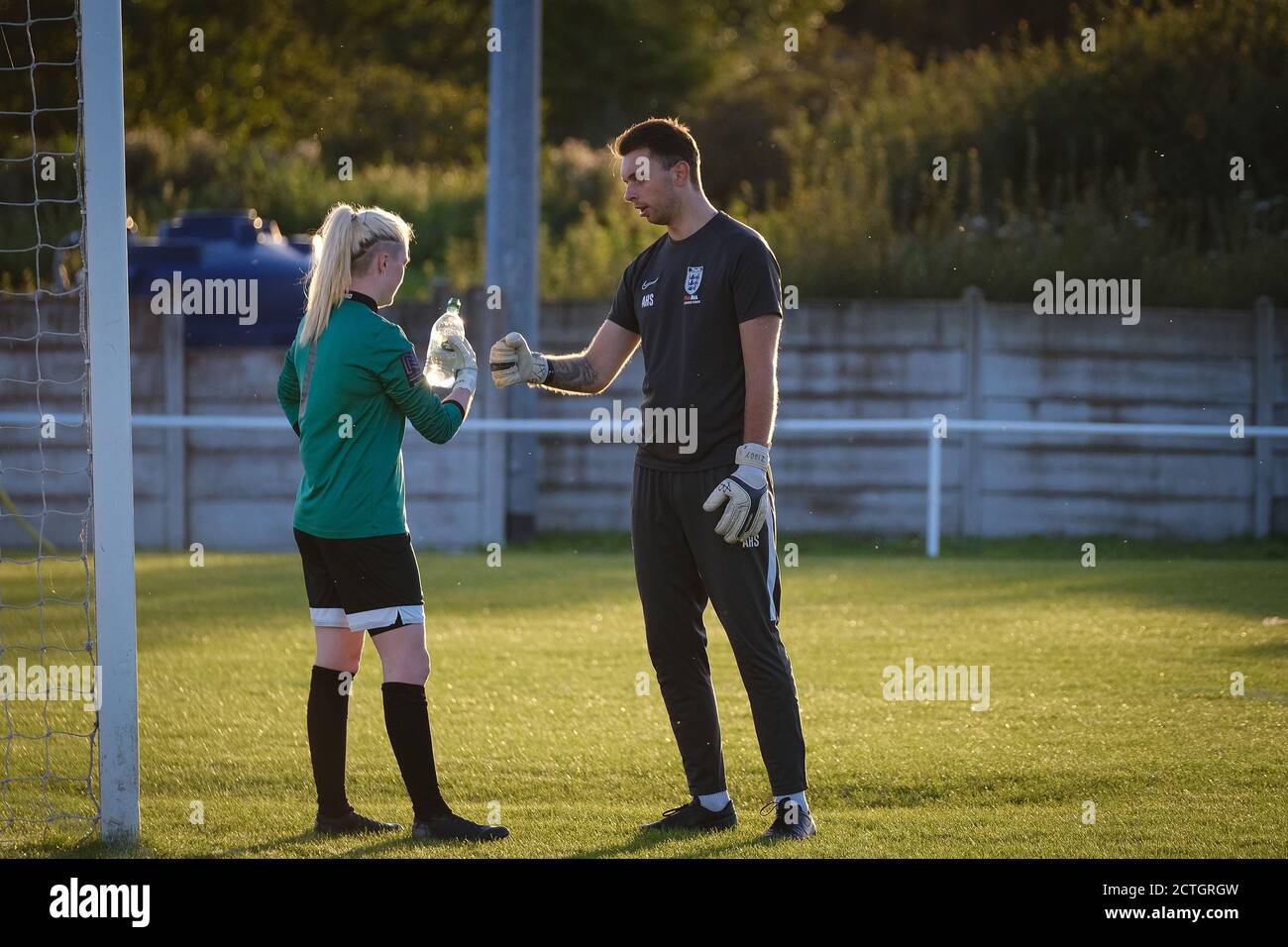 Torwartin für Fylde Frauen mit dem Torwarttrainer. Alex Hilton-Slee Stockfoto