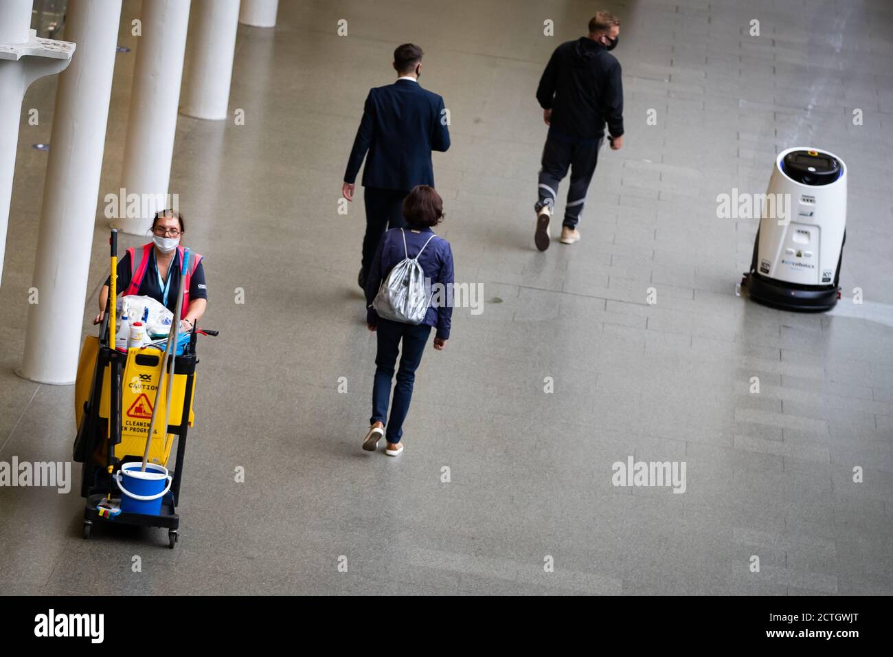 Ein Eco bot 50-Roboter reinigt und desinfiziert Oberflächen gleichzeitig mit einem automatischen Scheuersaugtrockner in St Pancras International, London, da er der erste Bahnhof der Welt ist, der High-Tech-Reinigungsroboter verwendet, um Viren in der gesamten Bahnhofsanlage und den Einrichtungen des historischen Wahrzeichen zu beseitigen. Stockfoto