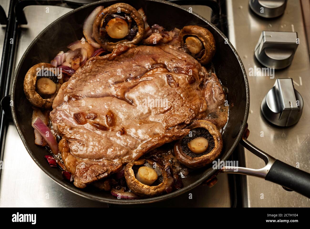 Rindersteak gebraten mit Pilzen und Zwiebeln Stockfoto
