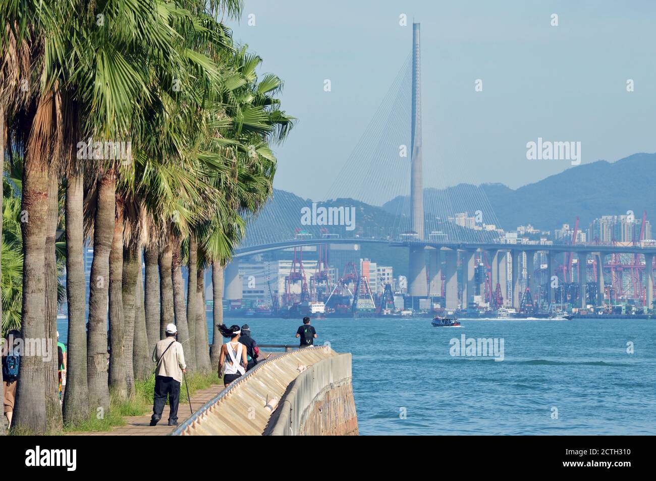 Uferpromenade in Sheung Wan, Hong Kong mit Victoria Harbour und Stonecutters Bridge im Hintergrund Stockfoto