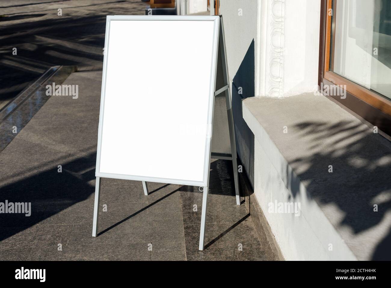 Schild auf der Straße. Abgewinkelter leerer Menütafel-Ständer. Restaurant Bürgersteig weißen Schild. Freistehende A-Rahmen Werbetafel in der Nähe von Outdoor-Café Stockfoto