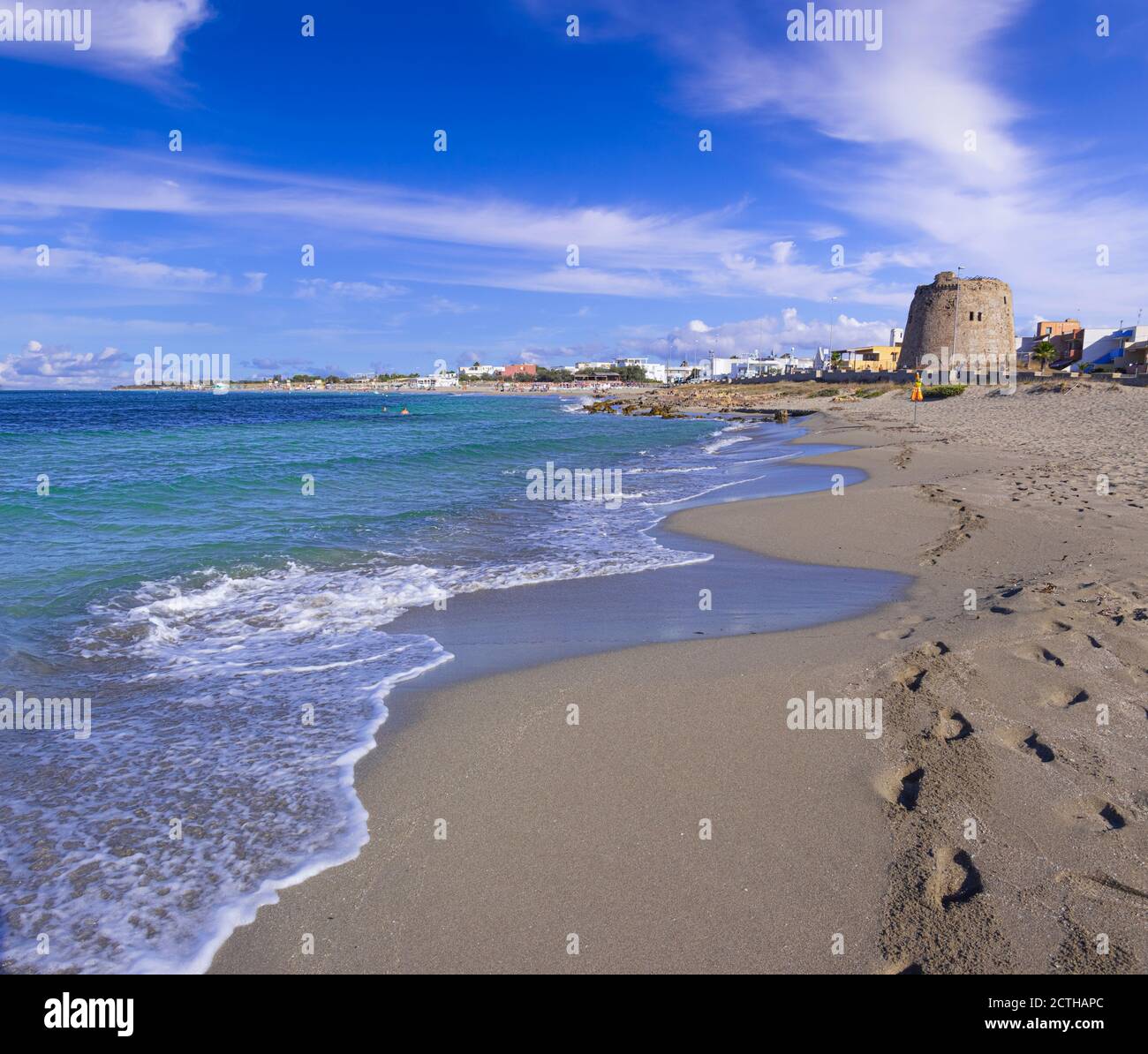 Strand von Torre Mozza in Salento, Apulien (Italien). Der ruinierte Wachturm blickt auf den langen Strand von Torre Mozza mit feinem Sand, der vom klaren Wasser umspült wird. Stockfoto