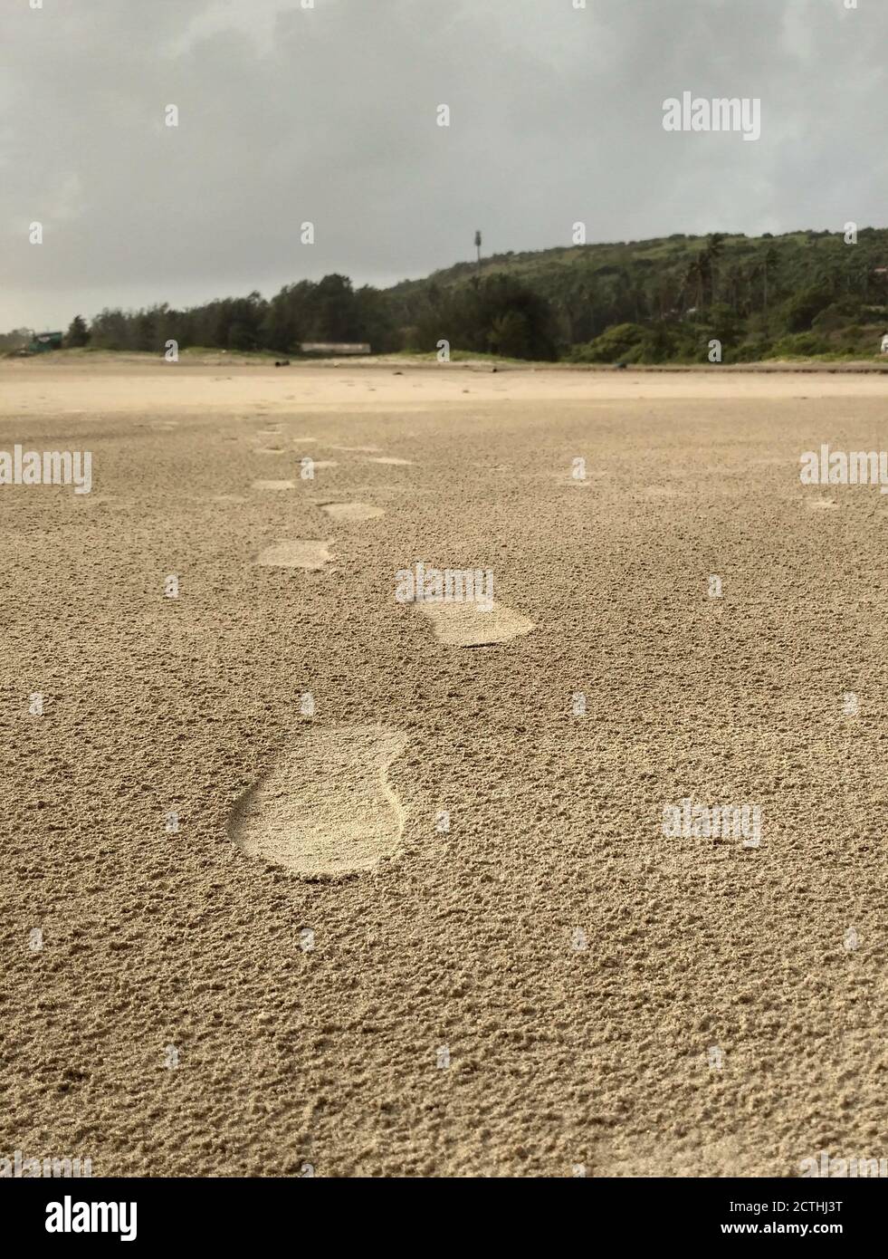 Fußabdrücke auf Mandrem Beach, Goa, Indien während der Monsunzeit. Wolkiger Tagesfußabdruck am Strand Stockfoto