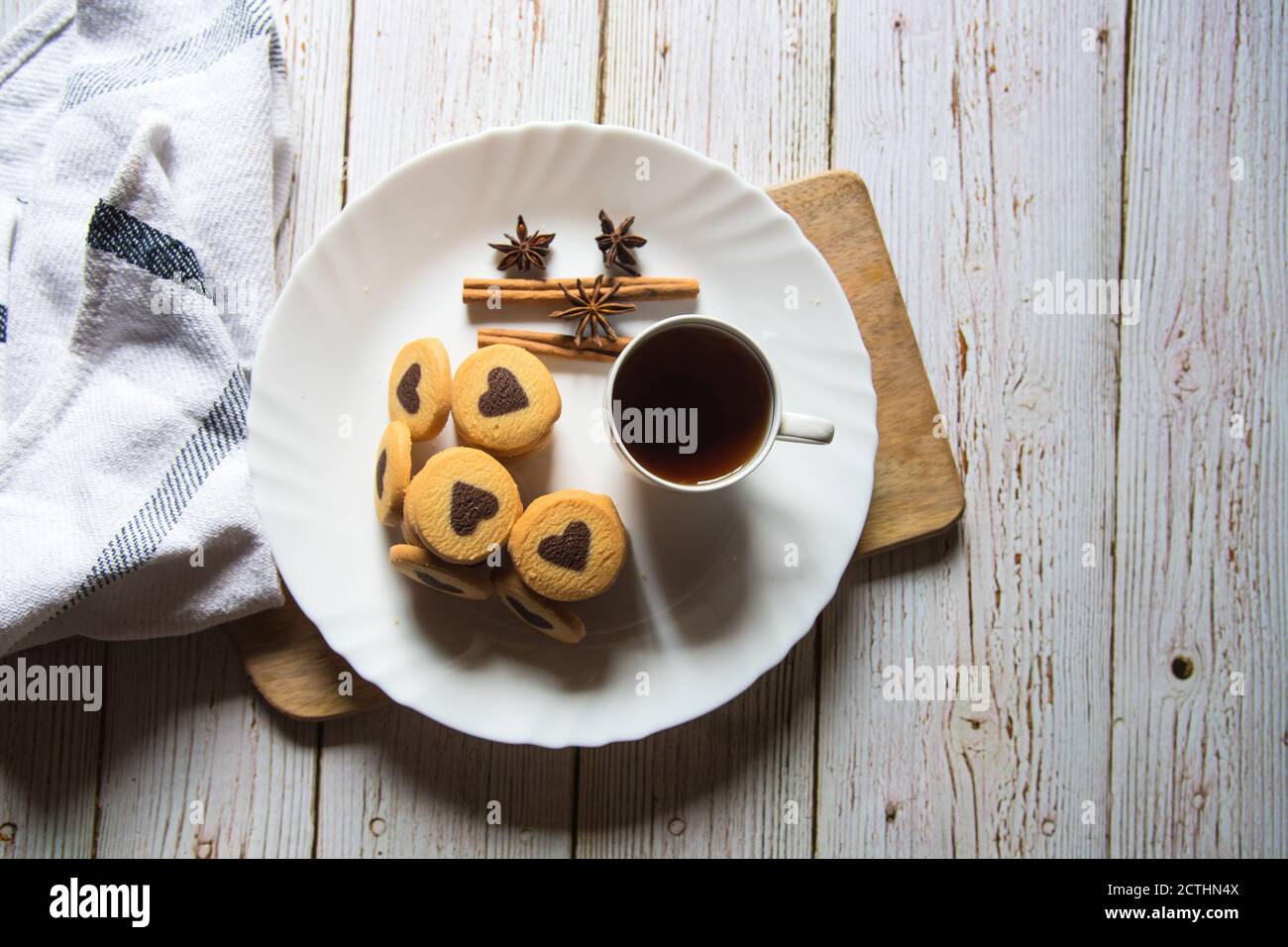 Schokoladenkekse in Herzform und schwarzer Kaffee in Weiß Platte auf einem Hintergrund Stockfoto
