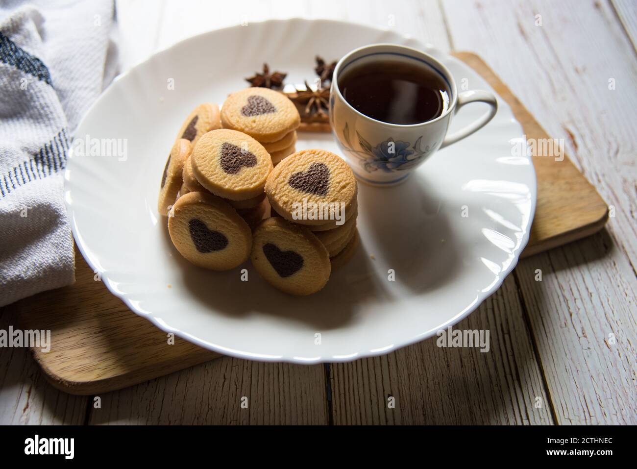 Nahaufnahme von herzförmigen Plätzchen und schwarzem Kaffee in Eine weiße Platte auf einem Hintergrund Stockfoto