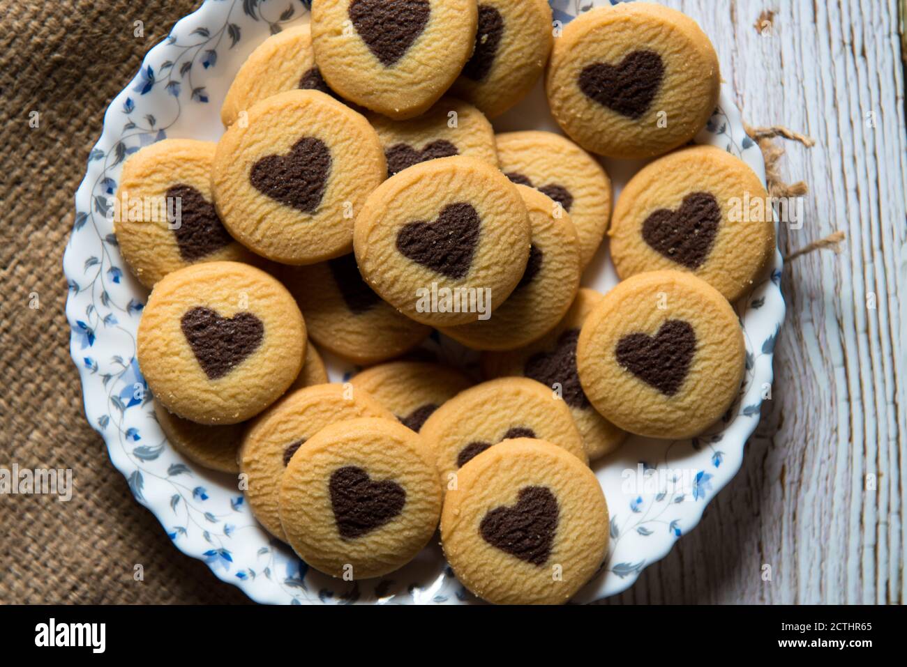 Blick von oben auf herzförmige Cookies auf einem Teller mit selektivem Fokus. Stockfoto